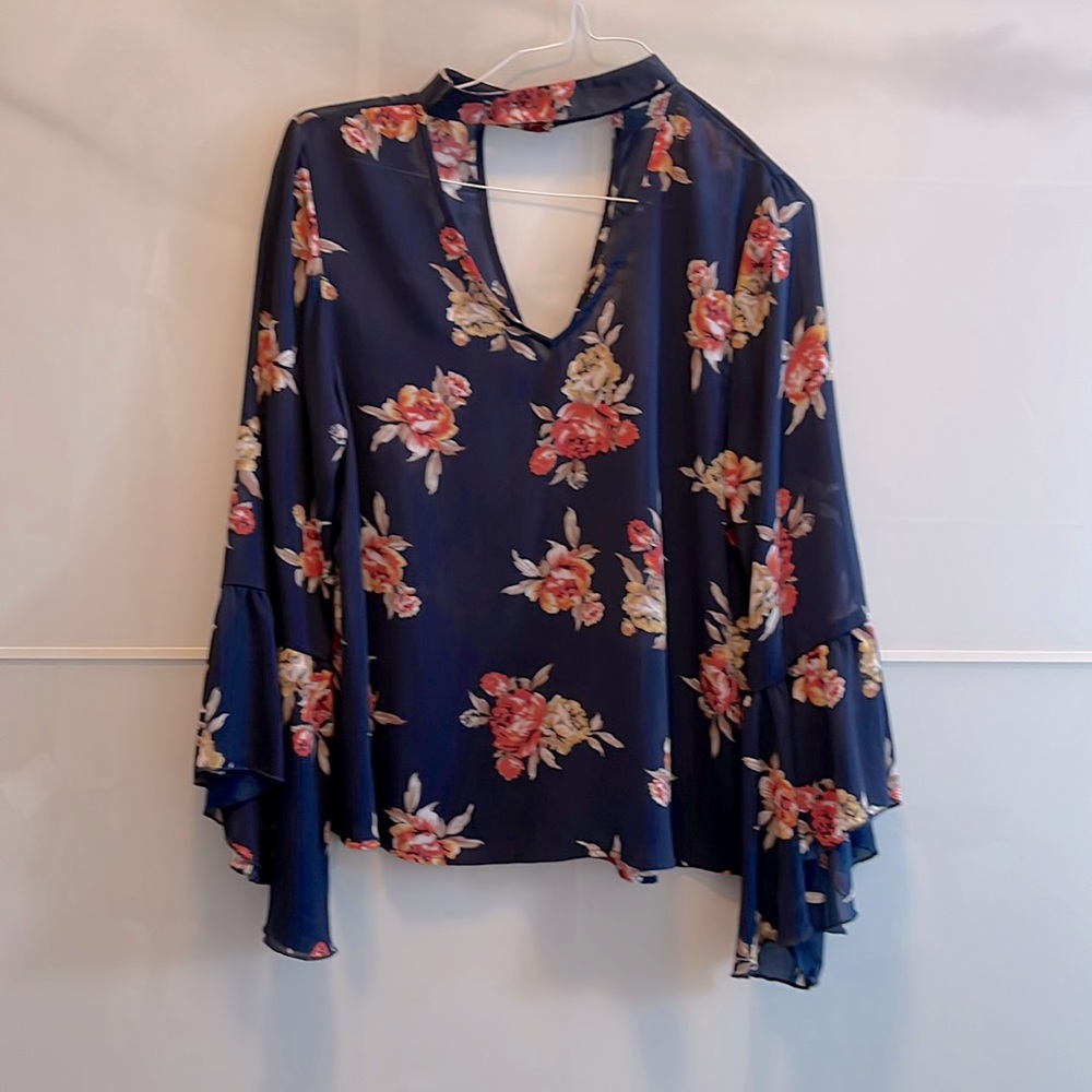 Blue lightweight top with flowers and bell sleeves.